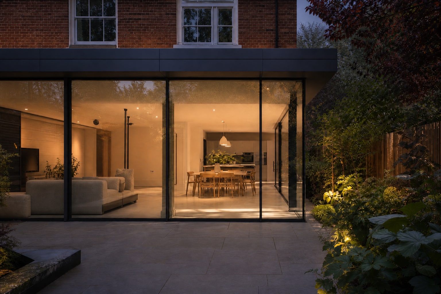 Dusk exterior with warm light through the glazing